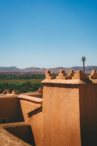 Terracotta fortress walls with green oasis below